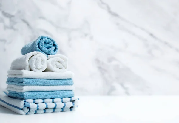 Towels stack on white table empty space background.Blue and white towel pile.