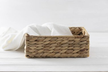 Beyaz havluyla süslenmiş saman sepeti boş reklam alanı, konteynır, tanıtım vitrini. Banyo ve scincare ürünleri için vitrin.