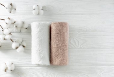 Yuvarlak banyo havluları, boş fotokopi alanı, beyaz ahşap arka planda pamuk çiçeklerle süslenmiş çamaşırlar. Kaplıca ve cilt bakım ürünleri sergileniyor..