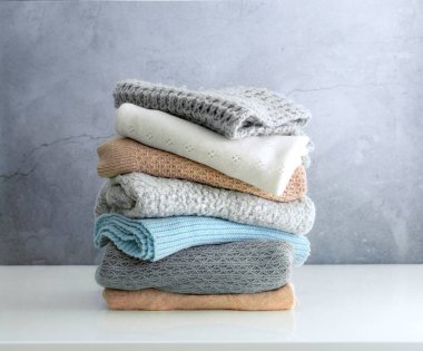 Yünlü giysiler masanın üstünde, örülmüş kazaklar katlanmış. Kış kıyafetleri, çamaşırlar. Kimse..