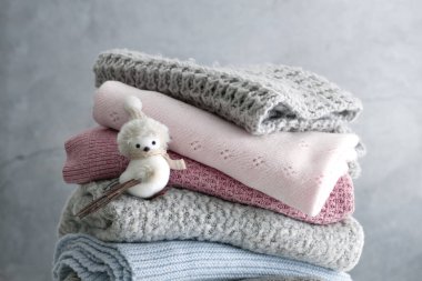 Gri arka planda katlanmış kış örgü giysileri yığını. Renkli kaşmir örgü. Kimse..