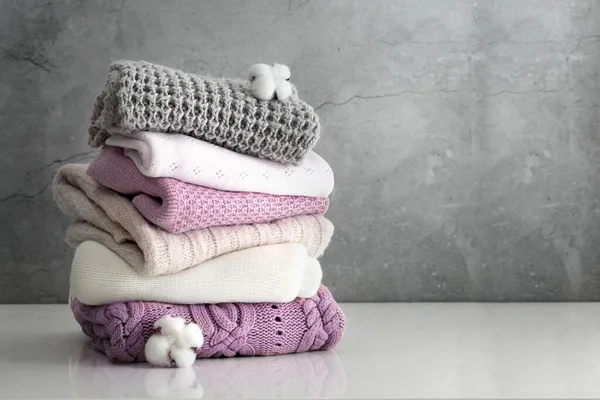 Kış örgülü giysiler boş uzay masasında katlanmış. Süveter yığını. Bir yığın örgü, çamaşır..