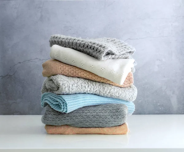 Yünlü giysiler masanın üstünde, örülmüş kazaklar katlanmış. Kış kıyafetleri, çamaşırlar. Kimse..