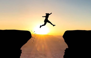 Woman jumping over abyss in front of sunset. clipart