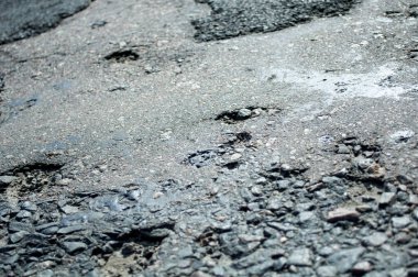 Yarı tahrip olmuş engebeli asfalt, eski yol üretim teknolojisi. Tehlike yüksek hızda. Delikler, çukurlar, granülerite.