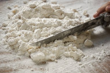 Kısa hamurlu hamur işi hazırlığı. Unu tereyağıyla kesiyorum. Tereyağlı un yığını, karıştır