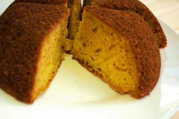 Dilimlenmiş, bölünmüş turta beyaz arka planda porsiyonlara ayrılır. Bir parça alınır.