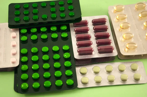 Yeşil arka planda ilaç, vitamin, tablet, ilaç kabarcıkları