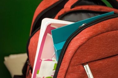 Okula hazırlanıyorum. Açık okul çantasından bir defter ve renkli kalemler görülebilir.