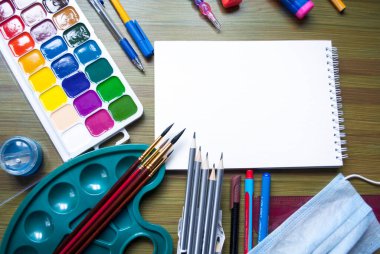 Öğrenci kâğıdıyla eğitim modeli ve ahşap arka planda beyaz eskiz defteri kağıdı. Çizim seti. Eğitim kavramı