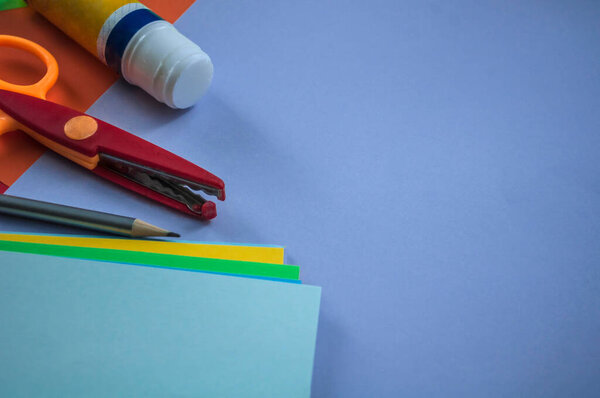 neatly laid out stationery along with a stack of other papers on blue cardboard to prepare for school lessons, still life, concept, back to school