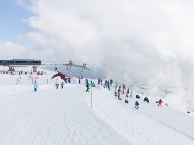 Sochi - 29 Şubat 2017: Mutlu insanlar ve kayak ve snowboard turist ve bir sürü beyaz kar ve bulutlar yüksek dağlarda 29 Mart 2017, Sochi, Rusya Federasyonu