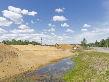 Kum ve çakıl yığın teknoloji ve sarı kum ve su birikintileri çok kırsal kesimde yeni bir büyük yol inşaatı