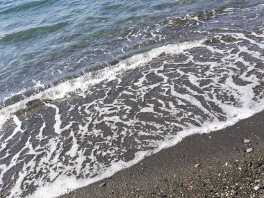 bir çakıl taşlı Plajı ve berrak denizi dalga deniz köpük