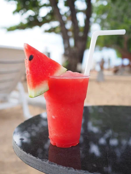 スイカのプラスチックのカップが夏にビーチでリフレッシュ ジュースを振る — ストック写真