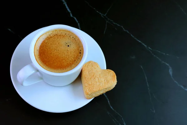 Filiżanka Kawy Espresso Ciasteczkiem Kształcie Serca Czarnym Stole — Zdjęcie stockowe