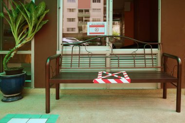 Coronavirus 'tan korunmak için SOSYAL DISTANCING için halka açık bir bankta işaretle