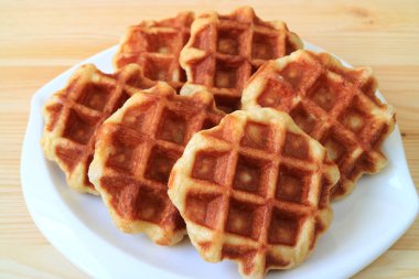 Tahta Masa üzerinde servis edilen beyaz tabakta nefis Belçika Waffle 'ları