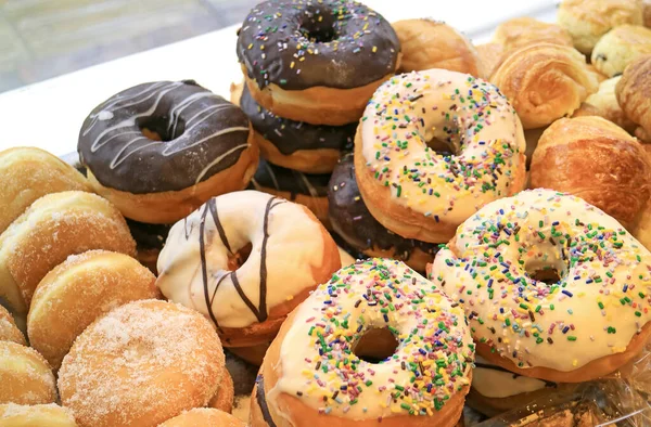 Heap of assorted doughnuts on the shelf of a bakery shop