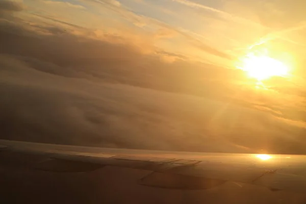 飛行機の窓から見える雲の上に輝く太陽 — ストック写真