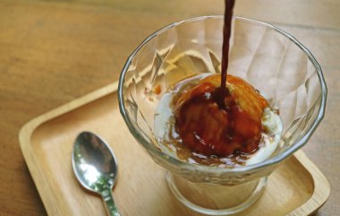 Bir bardak espresso kahve bir Affogato için doğrudan vanilyalı dondurmanın üzerine döküldü.