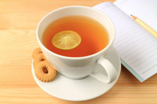 Kurabiyeli Sıcak Limon Çayı Ahşap Masa Üzerine Çizgili Kağıtları — Stok fotoğraf