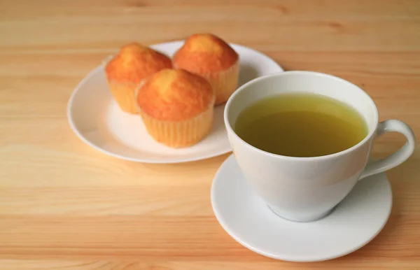 Geschlossener Heißer Grüner Tee Auf Holztisch Mit Verschwommenem Madeleine Cupcake — Stockfoto