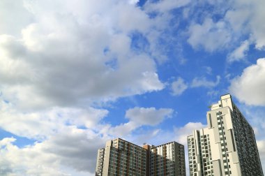 Tüylü beyaz bulutlar ve canlı mavi gökyüzü Bangkok, Tayland 'daki yüksek binaların üzerinde