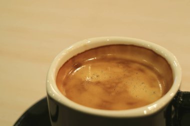 Kapalı bir fincan sıcak kahve Tahta Masa üzerinde servis edilir