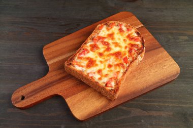 Tahta ekmek tahtasına izole edilmiş ev yapımı domates ve peynirli pizza.