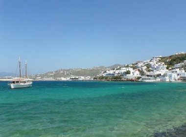 Beyaz balıkçı teknesi ve mavi gökyüzü ile mavi deniz arasındaki küçük kasaba, Yunanistan, Mykonos Adası