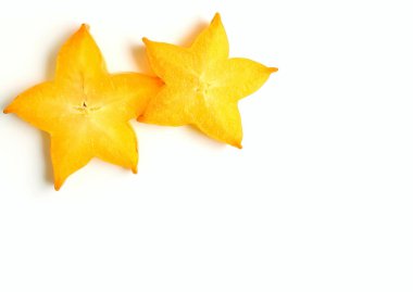 Beyaz zemin üzerinde, yazı ve tasarım için boş alanı olan iki canlı, sarı dilimlenmiş, olgun Star Fruits dokusu.