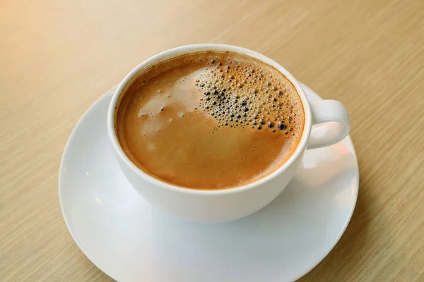 Kopje Hete Koffie Met Schuimige Ondergrond Geïsoleerd Houten Tafel — Stockfoto