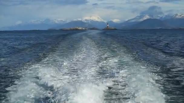 Agua espumosa en popa de crucero con faro les eclaireurs en la distancia, canal Beagle, Ushuaia, Tierra del Fuego, Argentina — Vídeos de Stock