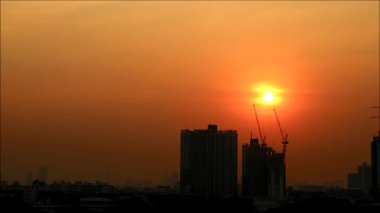 Bangkok, Tayland 'ın banliyölerindeki inşaat binalarının üzerinde güzel bir güneş batıyor.