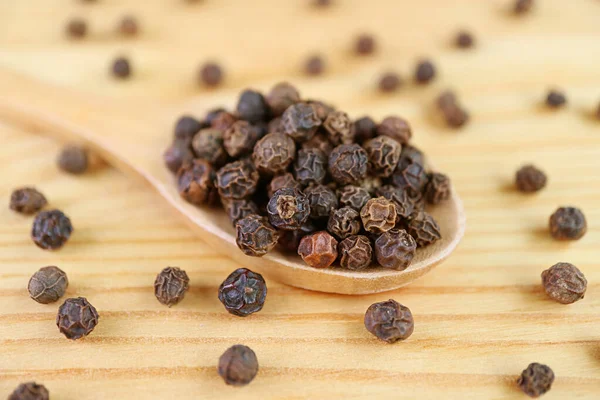 Closeup Texture Black Peppercorns Wooden Spoon Some Scattered — Stock Photo, Image