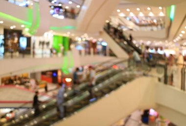 Yürüyen merdivenlerdeki insanlarla dolu soyut bir alışveriş merkezi.