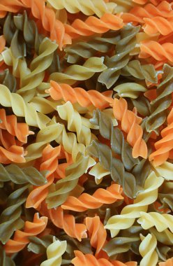 Arkaplan ya da pankart için üç renkli pişmemiş fusilli makarna yığını