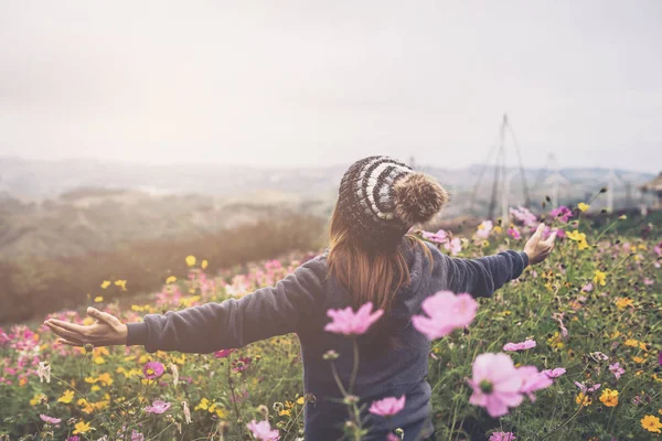山の花畑に歩く若い女性旅行者 — ストック写真