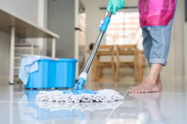 Genç kadın kat oturma odasında temizlik paspas ve kova, ev kavramı ile