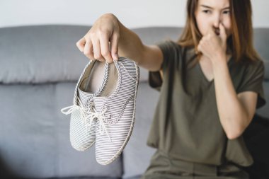 Kokuşmuş ve pis kokulu Ayakkabı evde tutan Genç Asyalı kadın