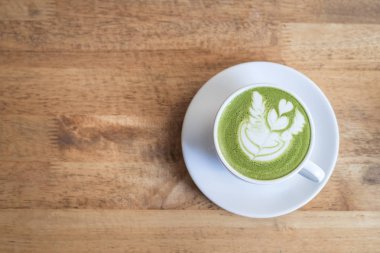 Fincan yeşil çay latte art Tarih ahşap masa, üstten görünüm