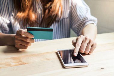 Bir kredi kartı tutan ve smartphone kullanarak genç kadın