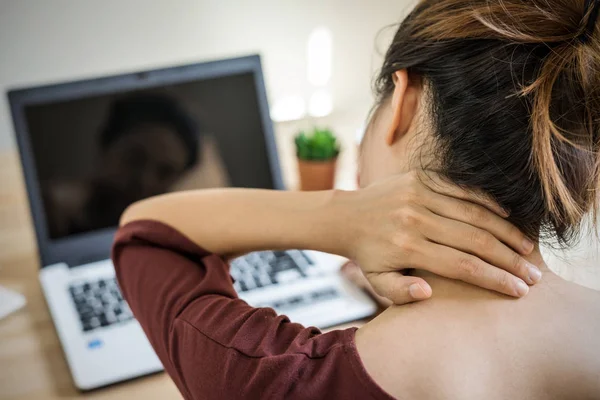 Giovane donna che lavora a casa e ha dolore al collo — Foto Stock