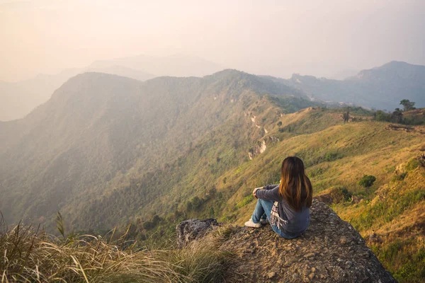 Młoda kobieta samotnie siedzi i patrzy na piękny krajobraz — Zdjęcie stockowe