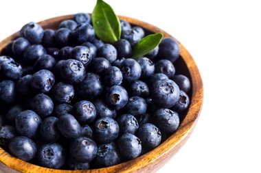 Beyaz kase yeşil yaprakları ile sulu ve taze yaban mersini. HEA