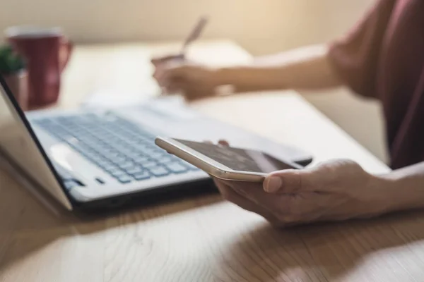 Giovane donna che utilizza smartphone e laptop — Foto Stock