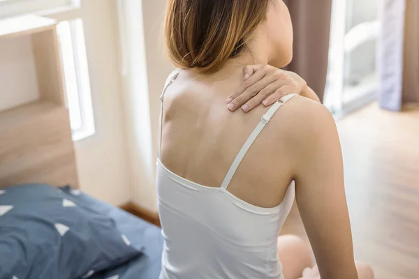 Donna che soffre di dolore al collo sul letto — Foto Stock