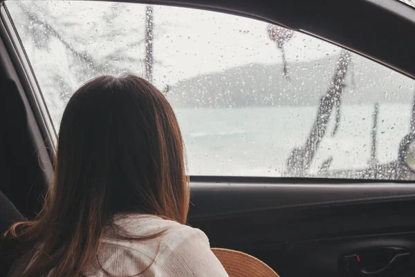 Triste giovane donna viaggiatore all'interno della macchina in giornata piovosa cercando thr — Foto Stock
