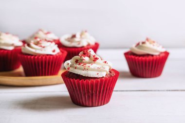 Beyaz ahşap masa üzerinde kırmızı kadife cupcake